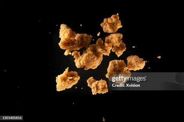 fried chicken meat flying in mid air captured with high speed sync. - fried stock pictures, royalty-free photos & images