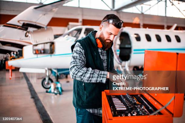 aircraft mechanic picking a right size socket from a mechanic's tool trolley in a repair hangar - pedicab stock pictures, royalty-free photos & images