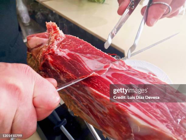 iberian ham cut with knife. - serrano ham foto e immagini stock