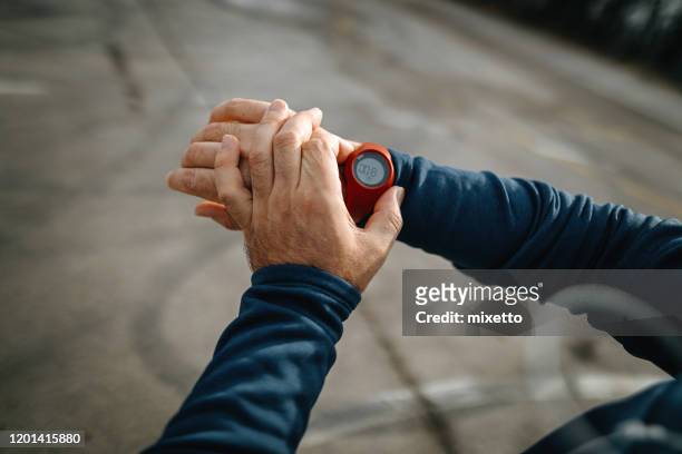 mature men running and using smart watch outdoors - personal perspective or pov stock pictures, royalty-free photos & images