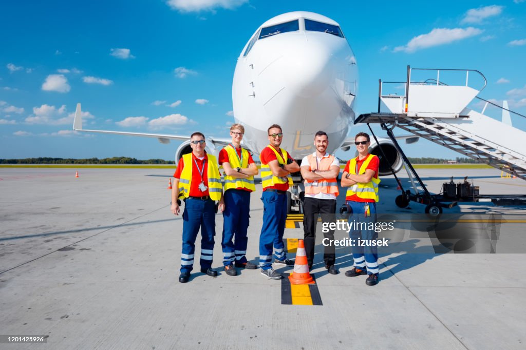 Airport ground crew in front of aircraft