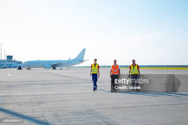 équipage au sol d'aéroport marchant sur la piste - piste daéroport photos et images de collection
