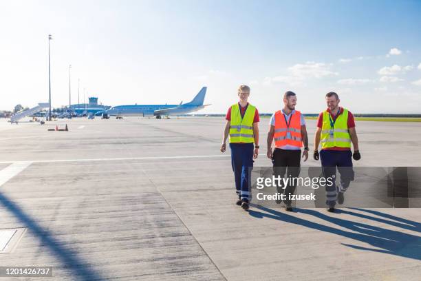 airport ground crew walking on the runway - ground crew stock pictures, royalty-free photos & images