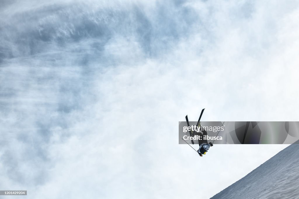 Skiër die een backflipsprong in het skigebied van alpen, Alpe di Mera, Piemonte, Italië doet