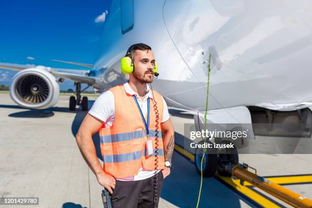 flughafen-bodenservice, mann vor dem flugzeug - airport ground crew uniform stock-fotos und bilder