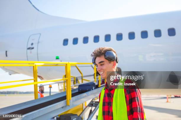 service au sol d'aéroport, jeune homme devant l'avion - piste daéroport photos et images de collection