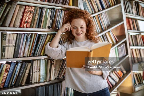 giovane donna che legge un libro - precious collection home foto e immagini stock