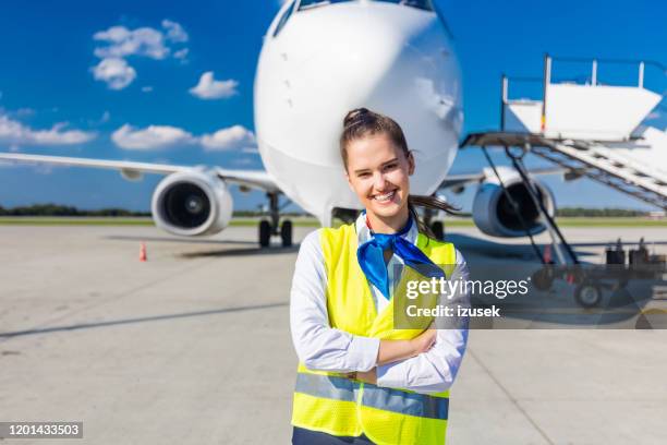 jeune femme de service d'aéroport devant l'avion - piste daéroport photos et images de collection