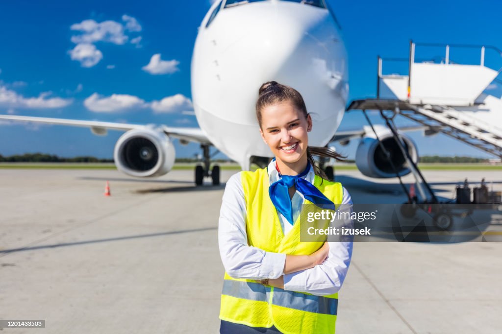 Airport service young woman in front of airplane