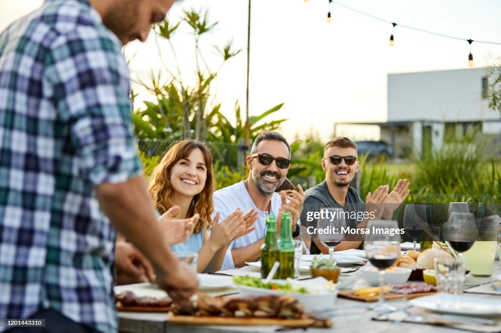 Happy friends celebrating Asado in backyard