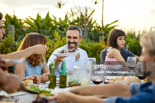 males and females celebrating asado in backyard - asado stock pictures, royalty-free photos & images