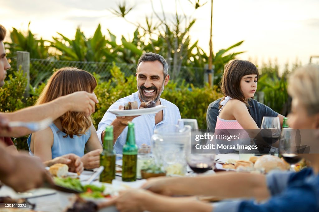 Males and females celebrating Asado in backyard