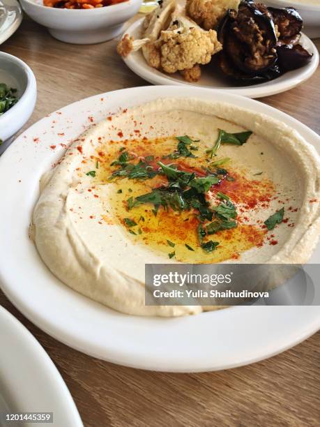 hummus with spices and olive oil served on a white plate - middle east oil stock pictures, royalty-free photos & images