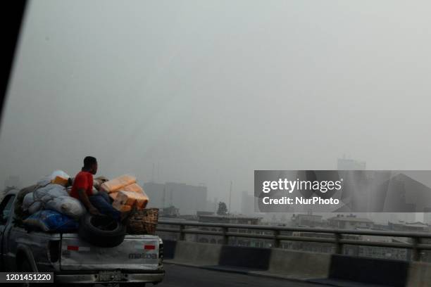 Man at the back of van looks at Lagos Island skyline, Nigeria as haze weather continues on Sunday February 16 2020. The bad weather has disrupted...