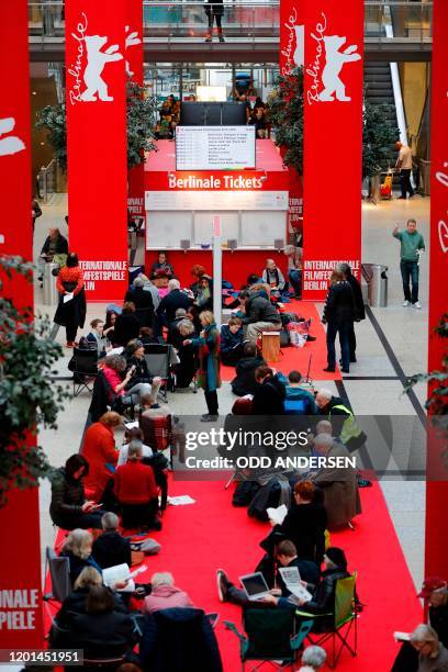 People queue as they wait for the 70th Berlinale film festival tickets to go on sale at the Potsdamer Arkaden mall in Berlin on February 17, 2020. -...