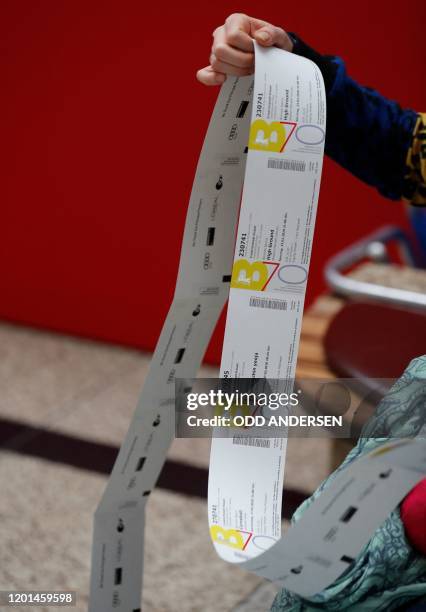 Festival goer checks out the purchased tickets for the 70th Berlinale film festival as the sale starts at the Potsdamer Arkaden mall in Berlin on...