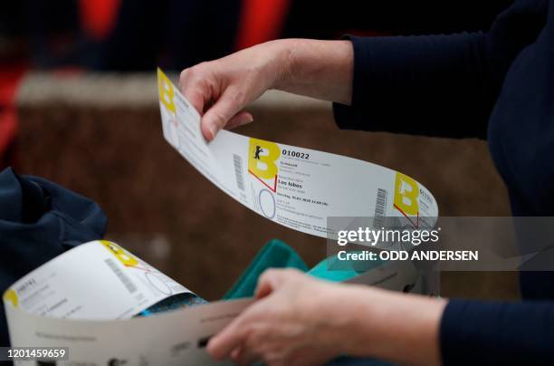Festival goer checks out her purchased tickets for the 70th Berlinale film festival as the sale starts at the Potsdamer Arkaden mall in Berlin on...