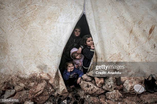 Children of Syrian families, who have been forcibly displaced due to the ongoing attacks carried out by Assad regime and its allies, look out of a...