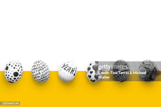 painted easter eggs on yellow and white background. flat lay. - funny easter eggs 個照片及圖片檔