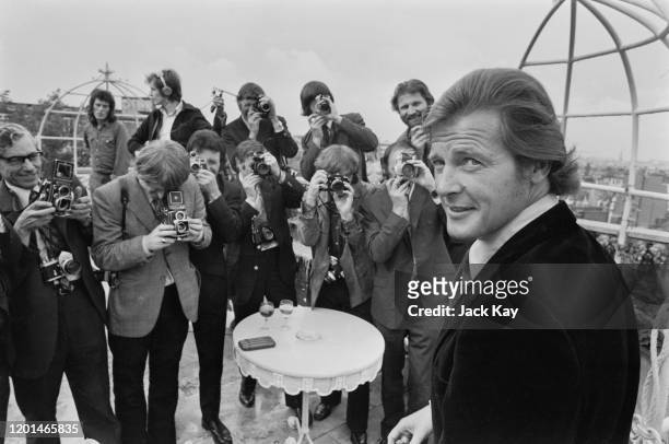 British actor Roger Moore stands before a group of photographers at the announcement that 'Live and Let Die' would be the next Bond film, the first...