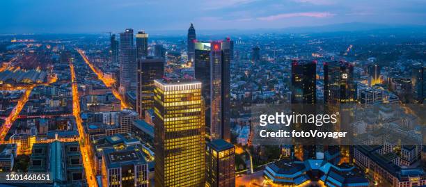 frankfurt aerial panorama over skyscrapers illuminated cityscape at sunset germany - messe frankfurt stock pictures, royalty-free photos & images