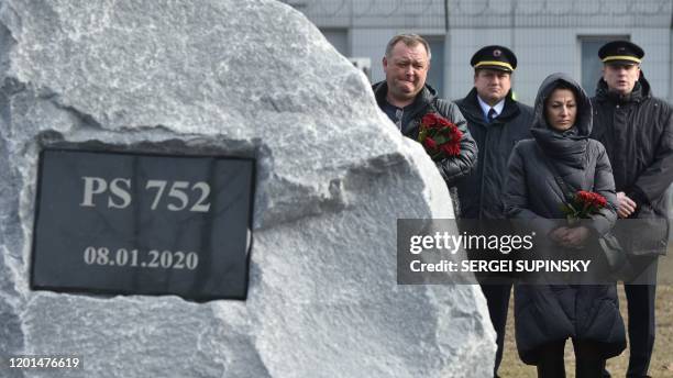 Relatives and colleagues of the 11 Ukrainians who died in a plane mistakenly shot down by Iran in January, attend a ceremony unveiling a memorial...