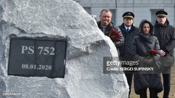 Relatives and colleagues of the 11 Ukrainians who died in a plane mistakenly shot down by Iran in January, attend a ceremony unveiling a memorial...