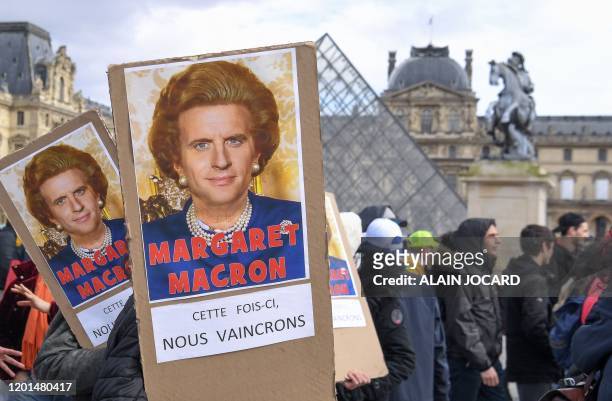 Protesters hold placards reading "Maragaret Macron, this time we will win" under a photomontage of both late British Prime Minister Margaret Thatcher...