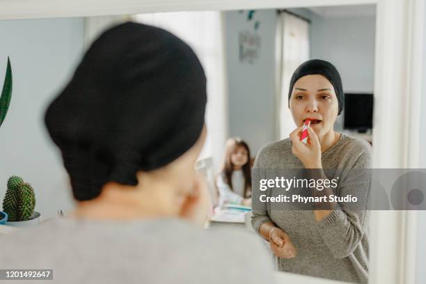 woman with cancer wears lipstick to feel good - bald girl stock pictures, royalty-free photos & images