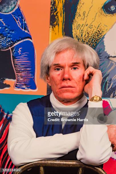 American Pop artist Andy Warhol sits in front of several paintings in his 'Endangered Species' at his studio, the Factory, in Union Square, New York,...