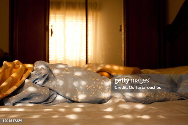 unmade bed spotted sun illuminated through blinds - morning sun stock pictures, royalty-free photos & images