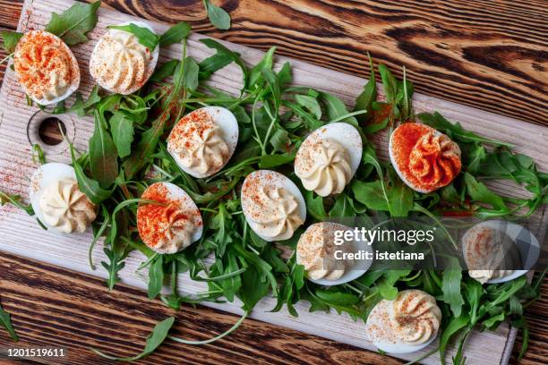 deviled eggs with paprika on fresh arugula salad - stuffing food stockfoto's en -beelden