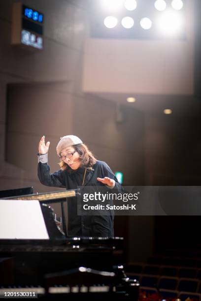 musikalischer dirigent im konzertsaal - dirigent stock-fotos und bilder
