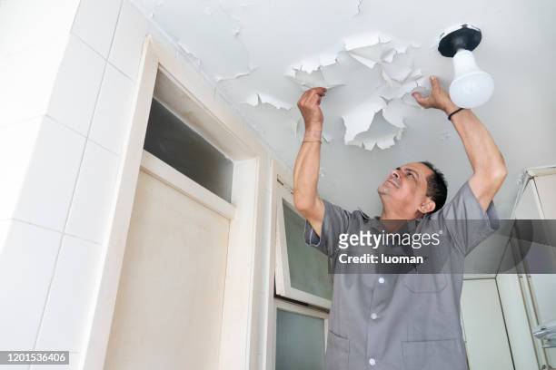 technician observes peeling kitchen ceiling - run down stock pictures, royalty-free photos & images