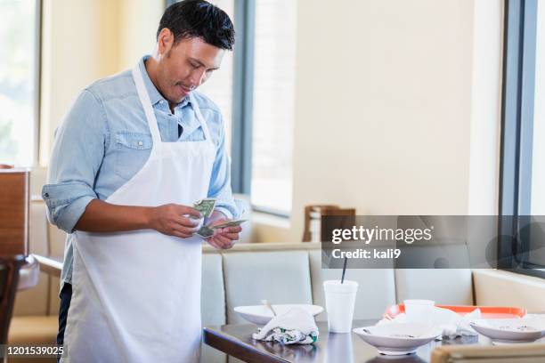 waiter in restaurant counting his tip - restaurant cleaning stock pictures, royalty-free photos & images