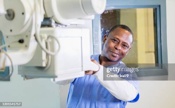 technologist using x-ray machine - radiographer stock pictures, royalty-free photos & images