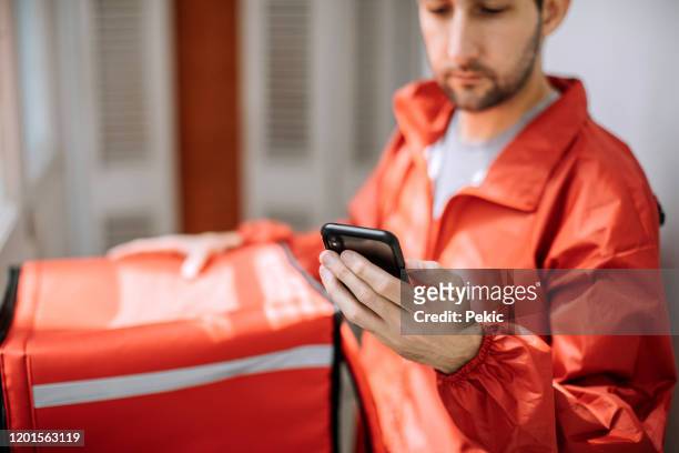 food delivery man getting ready for work - delivering imagens e fotografias de stock