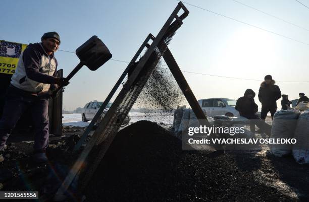 Men sell coal on the outskirts of the Kyrgyz capital of Bishkek on January 29, 2020. - Snow-capped peaks used to be clearly visible from the streets...