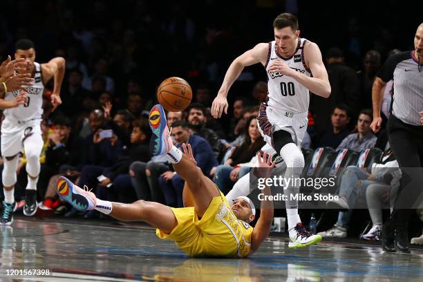 Jared Dudley of the Los Angeles Lakers falls to the court battling for the ball against Rodions Kurucs of the Brooklyn Nets at Barclays Center on...