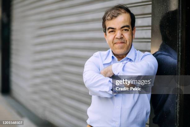 mid-adult businessman with dwarfism on the street - dwarf stock pictures, royalty-free photos & images