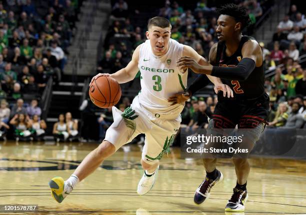 Payton Pritchard of the Oregon Ducks drives to the basket on Jonah Mathews of the USC Trojans during the first half at Matthew Knight Arena on...