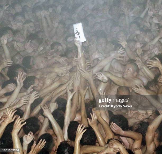 Men wearing only loincloths jostle in the cold in a bid to grab two sacred wooden sticks during the over-500-year-old Saidaiji Eyo festival at...