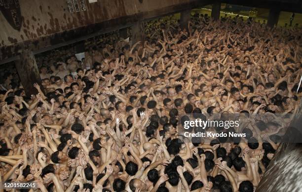 Men wearing only loincloths jostle in the cold in a bid to grab two sacred wooden sticks during the over-500-year-old Saidai-ji Eyo festival at...