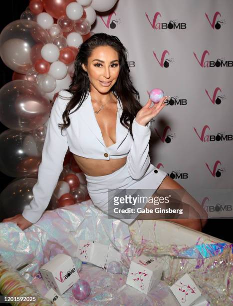 Adult film actress Christiana Cinn poses with a bath bomb from her new line of products at the VaBomb booth during the 2020 AVN Adult Expo at the...