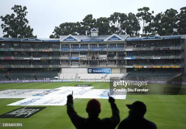 Spectators wait patiently as Rain falls during Day One of the Fourth Test between South Africa and England at The Wanderers on January 24, 2020 in...