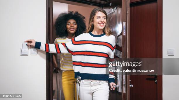 female friends arriving in the hotel and opening their room - abrir a porta sair imagens e fotografias de stock