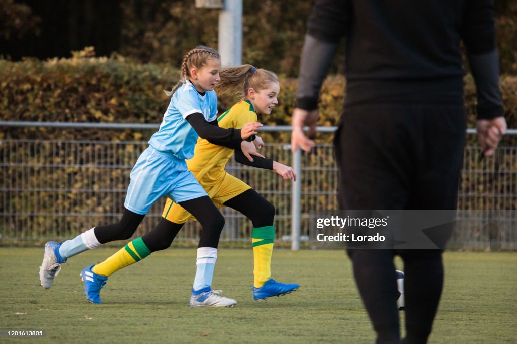 Mädchen, die während eines Abendfußballspiels Fußball spielen