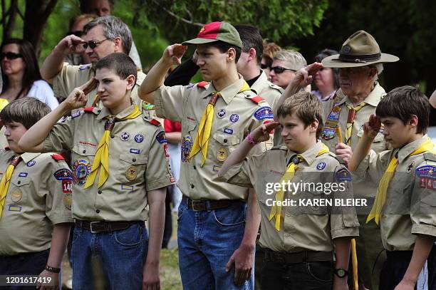 Members of the Boy Scouts salute during the raising of the flag on May 25, 2009 at the Willow River Cemetery in Hudson, Wisconsin during Memorial Day...