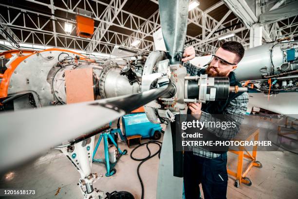 mecánico de aeronaves trabajando en un ensamblaje de hélice de un avión pequeño en un hangar - airplane part fotografías e imágenes de stock