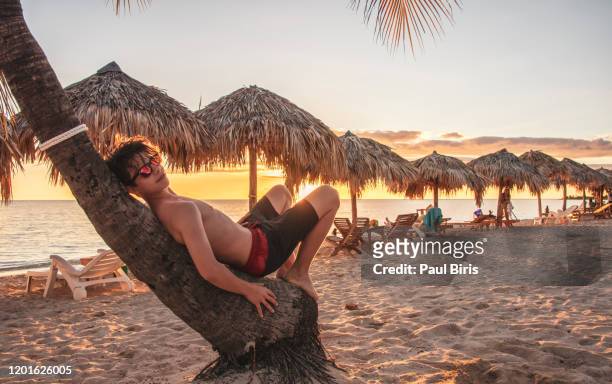 teenager chill out for lazy evening,  playa ancon,  trinidad, cuba - playa ancon cuba imagens e fotografias de stock